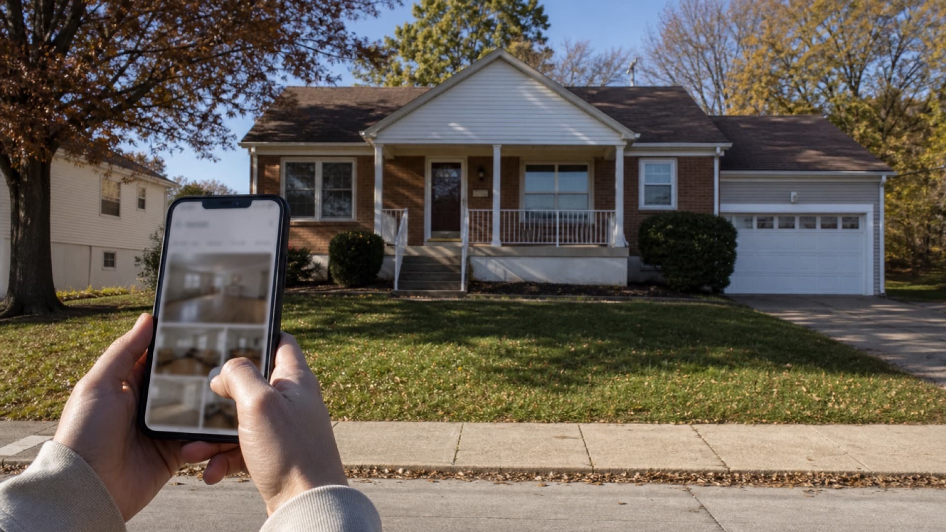 Renter verifying a listing on a smartphone in front of a Jefferson County home.